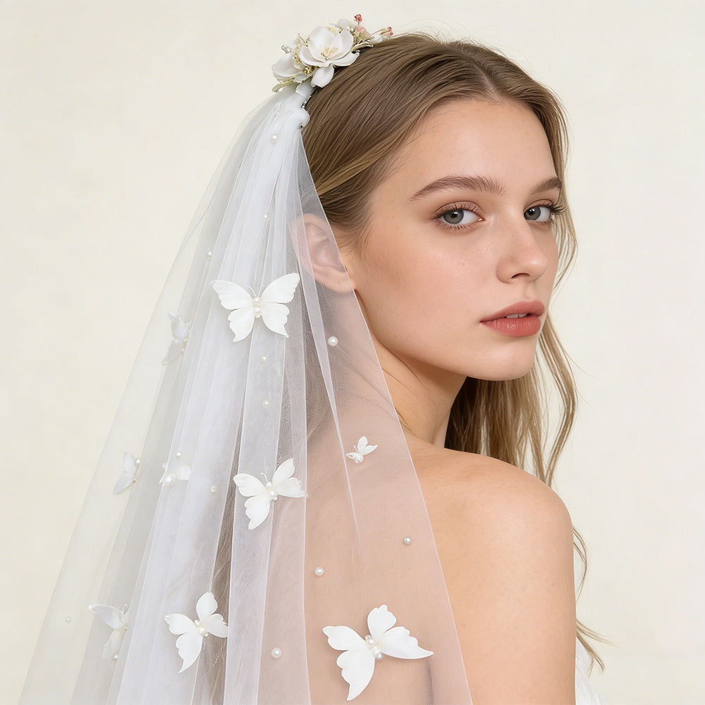 Bride wearing romantic butterfly pearl cathedral veil, close-up view of 3D butterfly and pearl details