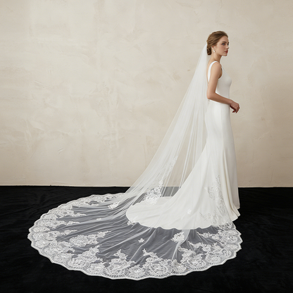 Bride wearing loral lace cathedral veil in church wedding
