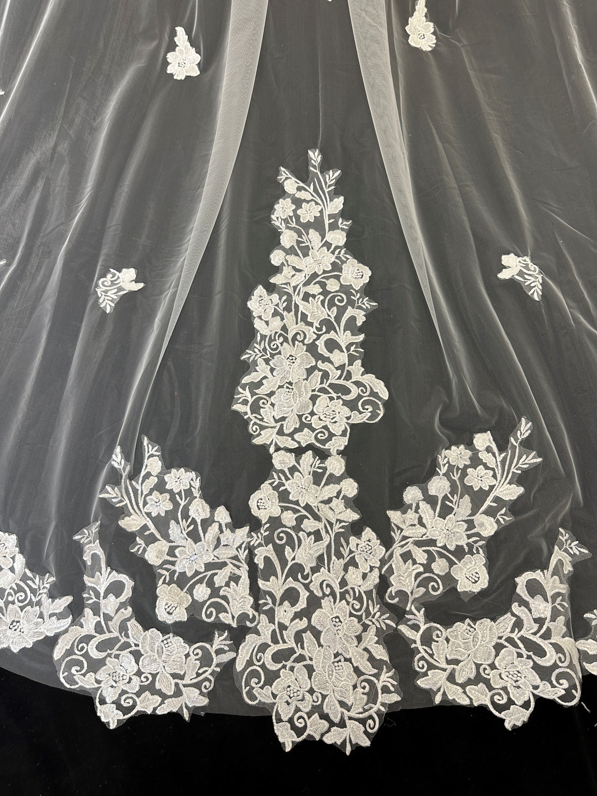 Close-up of delicate scattered floral embroidery on cathedral wedding veil 